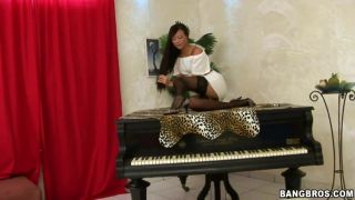 Bed A gorgeous brunette lies atop a grand piano Spread
